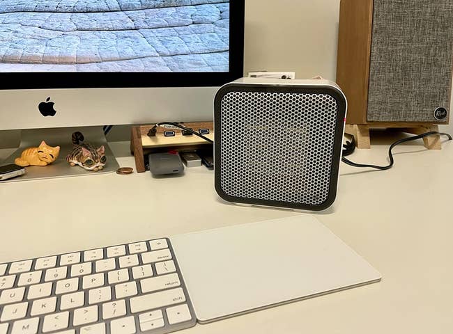 The space heater in white on a reviewer's desk