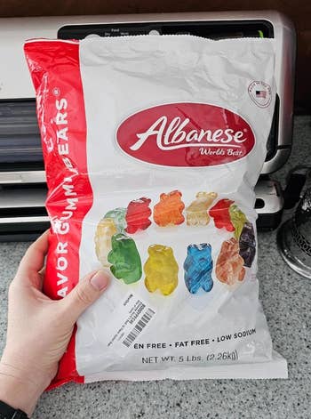 reviewer holding a bag of Albanese gummy bears