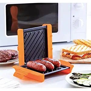 The panini press open with sausages inside