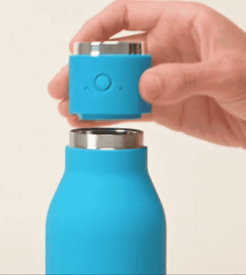 model's hand lifting the blue water bottle lid off to show it's a portable speaker