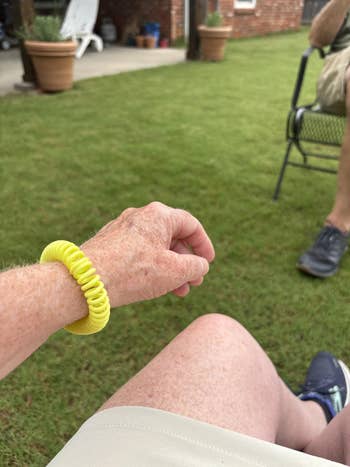 Reviewer sitting extracurricular and wearing the spiral mosquito repelling bracelet successful yellow