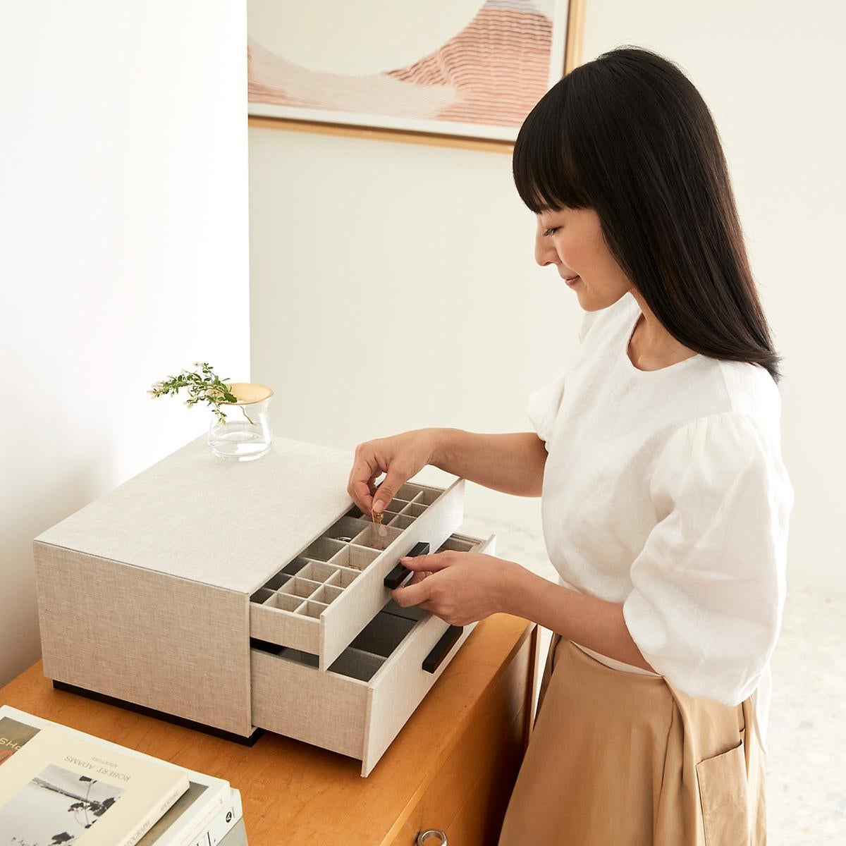 Marie Kondo putting earrings into linen jewelry box