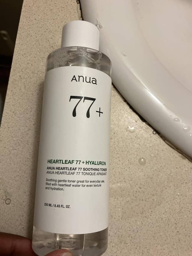 Anua Heartleaf 77+ Hyaluron Soothing Toner bottle on a bathroom counter. 250 ml size