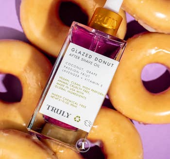 Bottle of Glazed Donut After Shave Oil by Truly Beauty amid donuts, highlighting its key ingredients and cruelty-free aspect