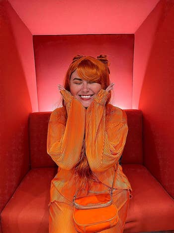 reviewer posing, wearing the set in orange