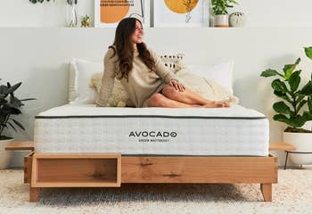 woman lying on Avocado Green Mattress on bed frame, with attacked book shelf