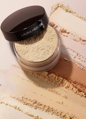Open jar of Laura Mercier translucent pulverization with scattered pulverization inheritance and testimonials claiming it controls shine, lasts long, and feels lightweight
