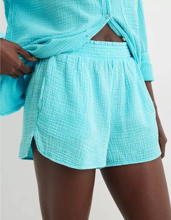 Close-up of another model in wearing a textured blue shorts with matching button-down top