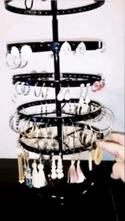 Image of reviewer spinning black earring holder with earrings hanging on holders 