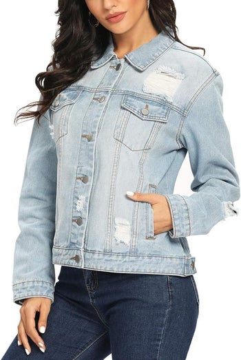 Model in a distressed denim jacket with button closure and pockets for a informal scrutinize