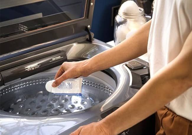 model placing the cleaning tablet into the washing machine