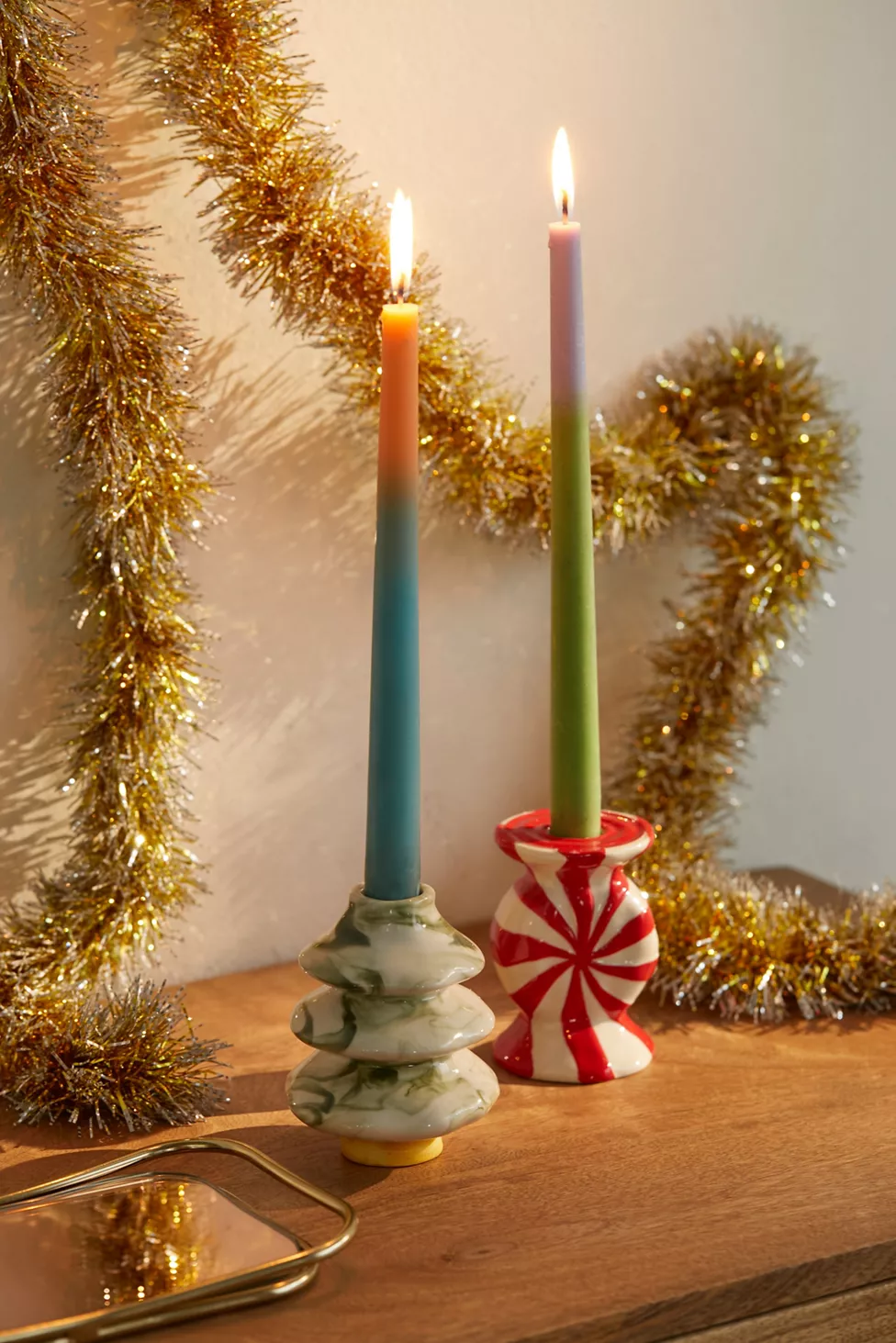 two taper candle holders: one is shaped like a tree and one is shaped like a peppermint candy