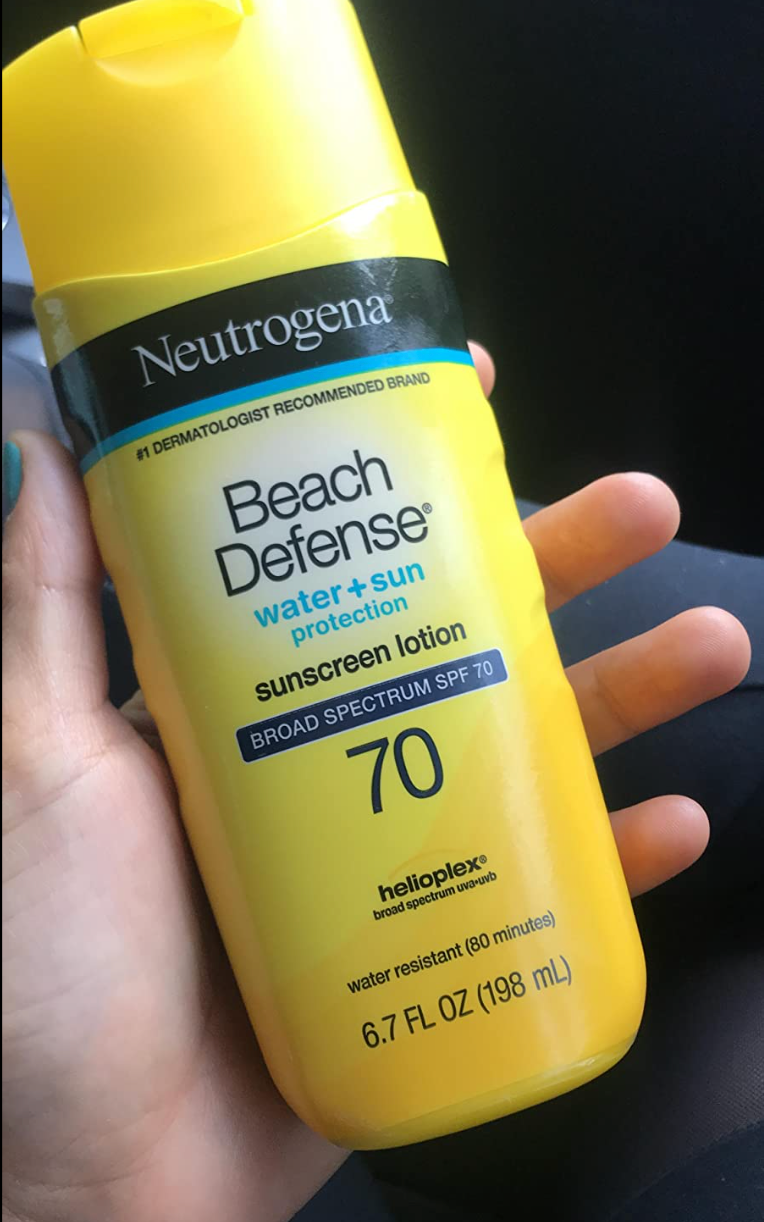 reviewer holding a bottle of sunscreen 