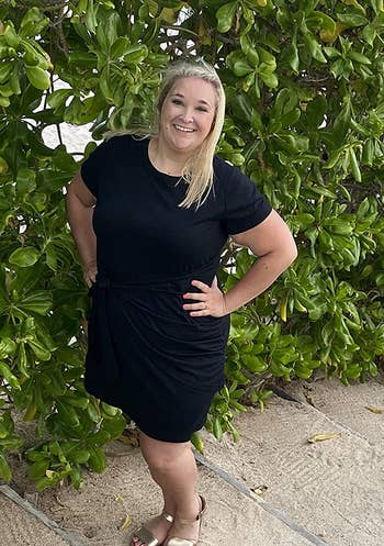 a reviewer wearing the tie-waist dress in black 