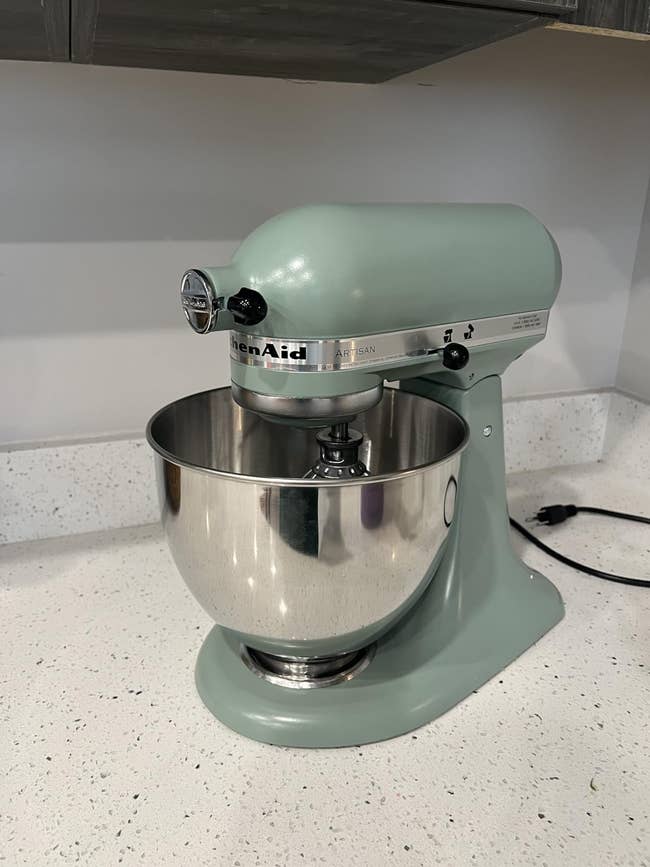 KitchenAid basal   mixer with a metallic  bowl, shown connected  a room  countertop for a buying  article