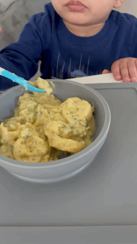 A gif showing a toddler eating from the bowl