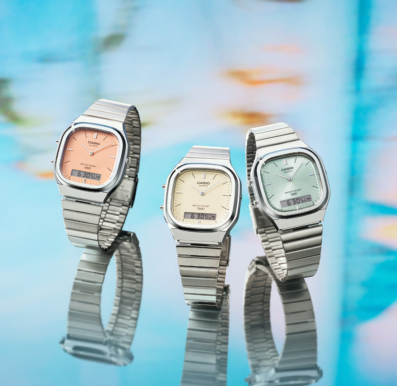 three watches with varying pastel colors of ticker  faces, including pink, yellow, and green