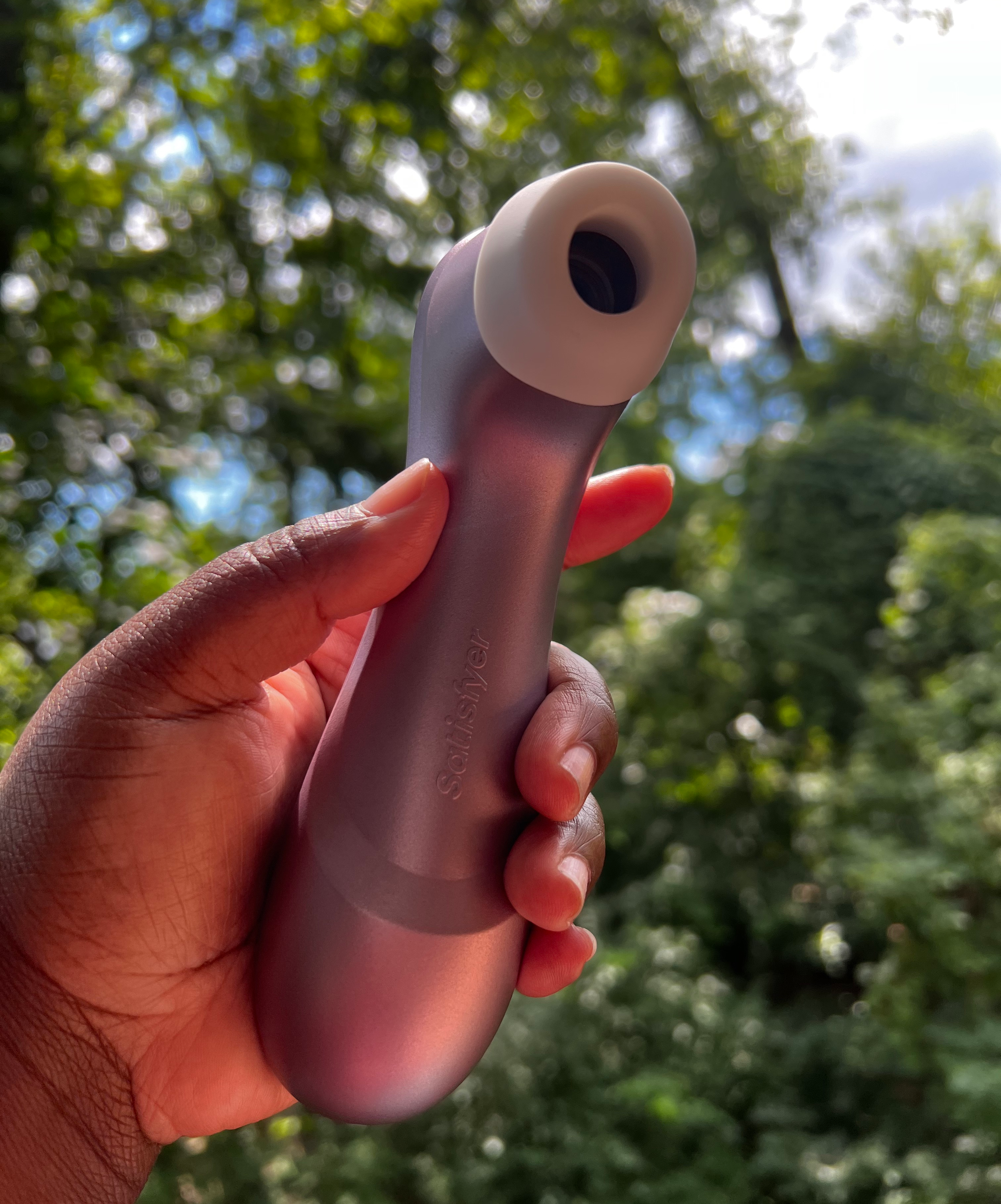 Hand holding purple suction vibrator