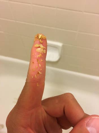 Reviewer's finger with ear wax on it