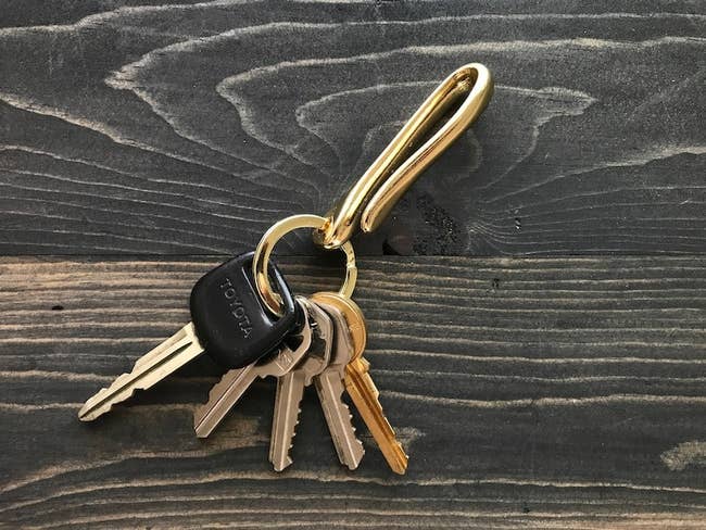A golden keychain with keys and a hook built in