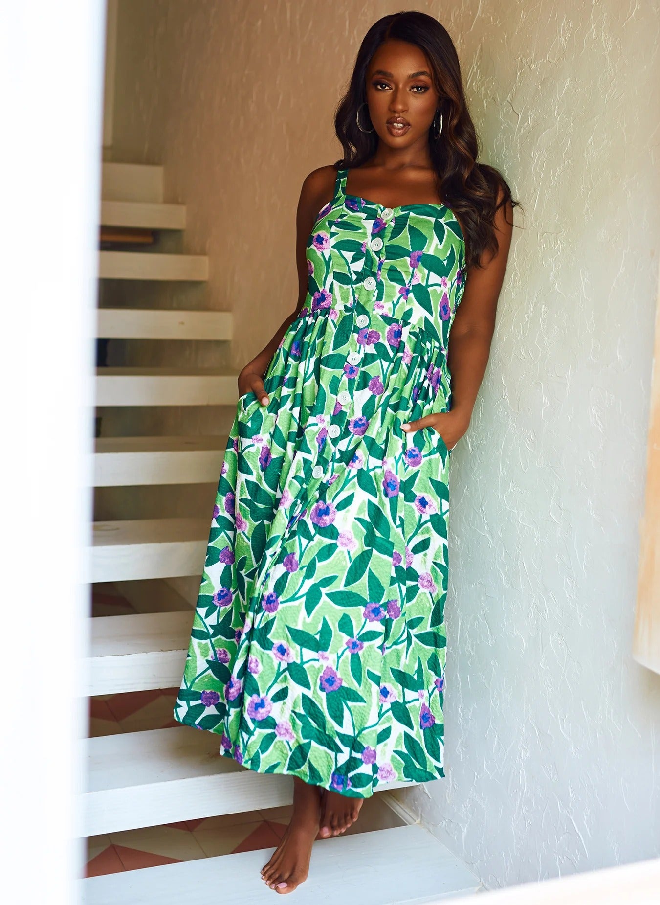 model in sleeveless sweetheart neckline button front green leaf and purple flower print dress