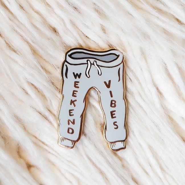 enamel pin shaped like gray sweatpants with the text 