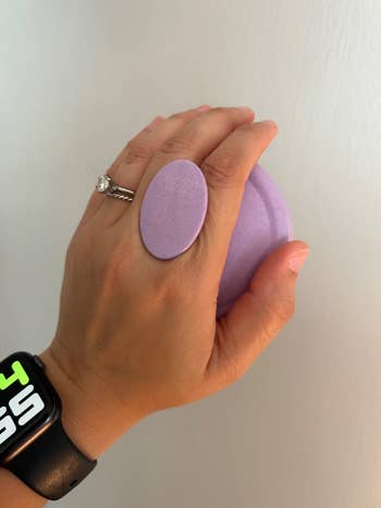 Hand holding a purple popular socket grip attached to scalp scrubber