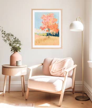 A beige seat  with a pinkish  propulsion  broad  sits beside a woody  broadside  array  with a potted plant, nether  a vibrant scenery  painting