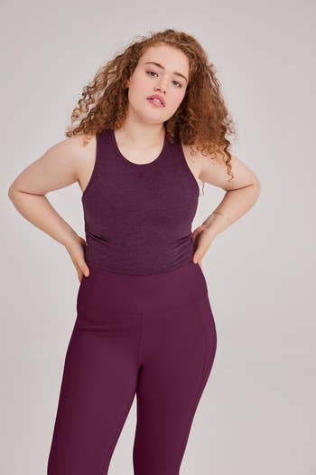 model wearing purple cropped tank top and leggings