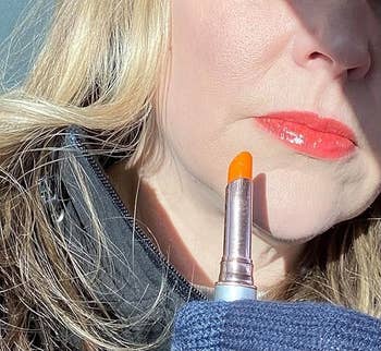 Close-up of idiosyncratic   holding conduit  of Jane Iredale articulator  stain adjacent  to glossy lips