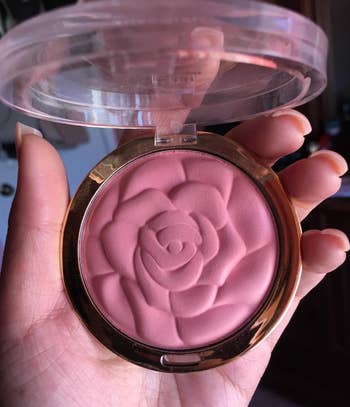 reviewer holding powder blush that's shaped as a rose