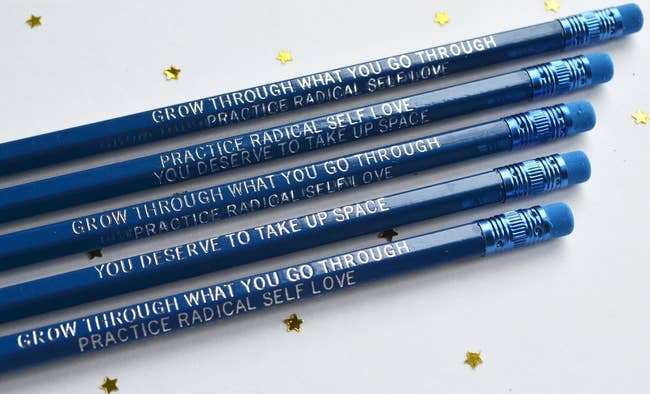 blue pencils etched with white self care sayings on them like you deserve to take up space and grow through what you go through