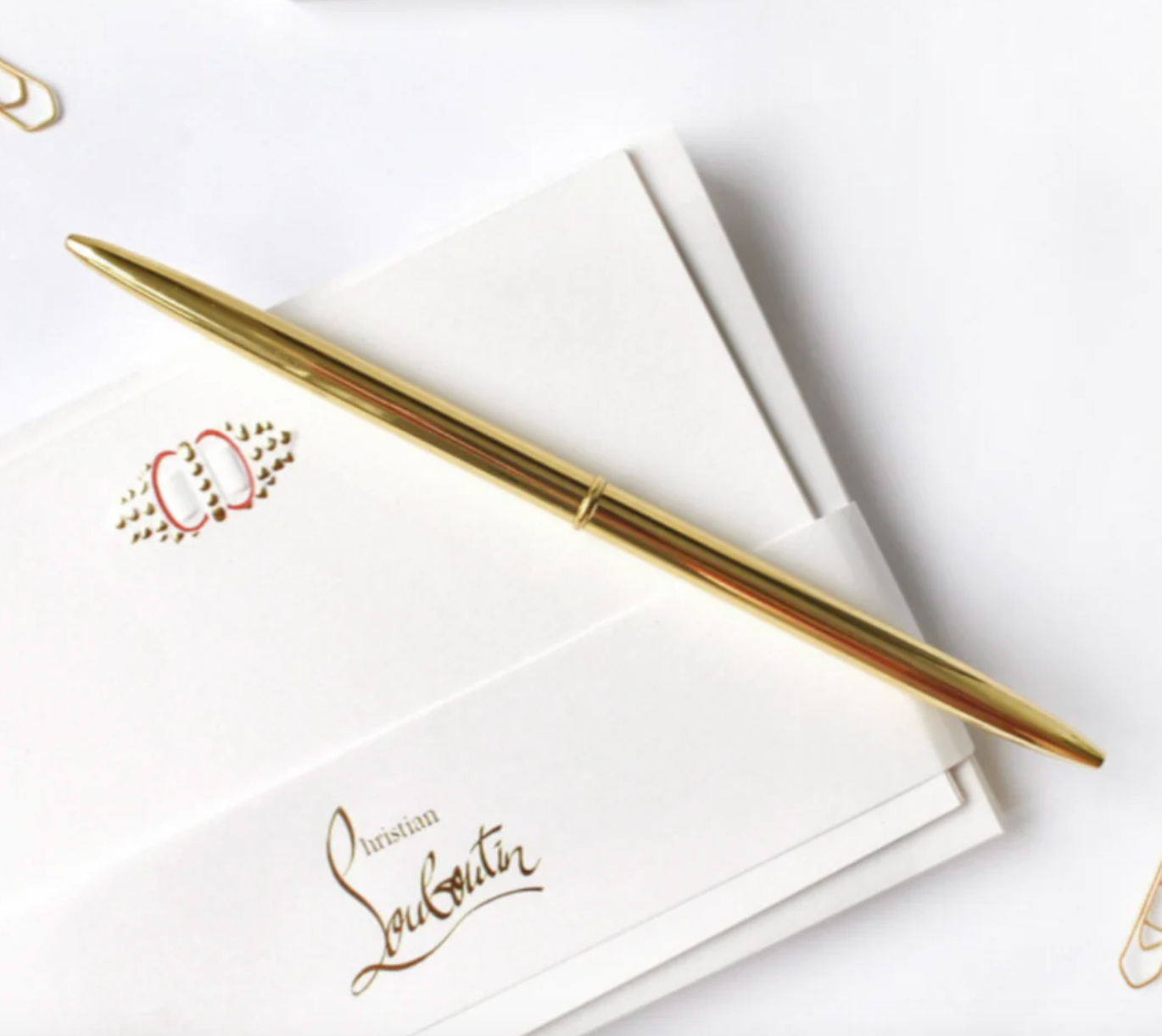 a gold pen on top of stationary
