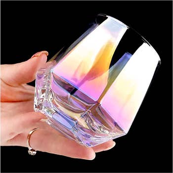 iridescent jewel cut stemless wine glass in model's hand 