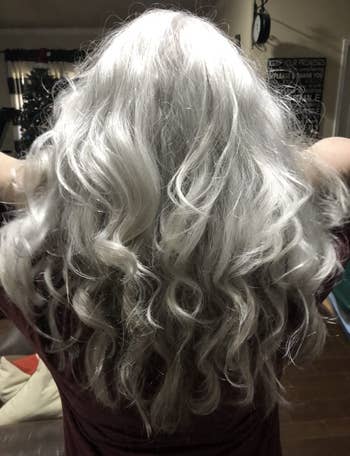reviewer with silver hair showing their smooth silky looking hair