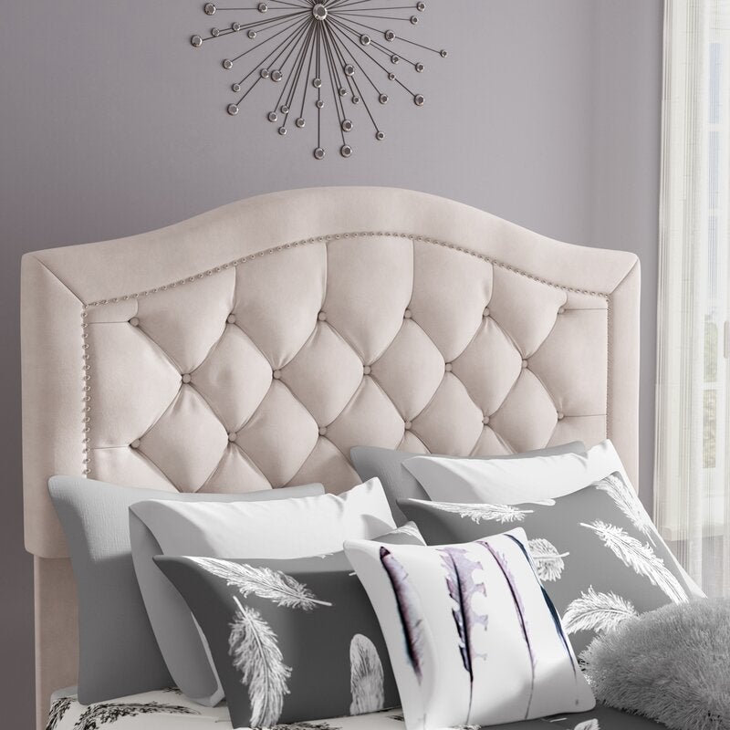 A cream headboard with an arch and upholstery