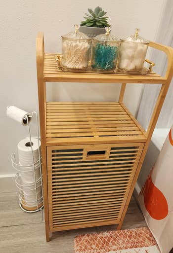 reviewer's bamboo storage shelf next to shower