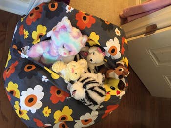 the floral-print bean bag open to reveal the stuffed animals inside