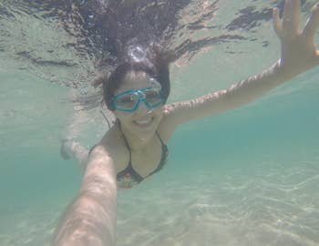 reviewer taking a selfie under water from using the protector pouch