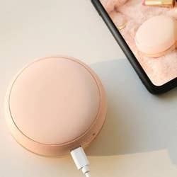 the pink macaron being used to charge a phone