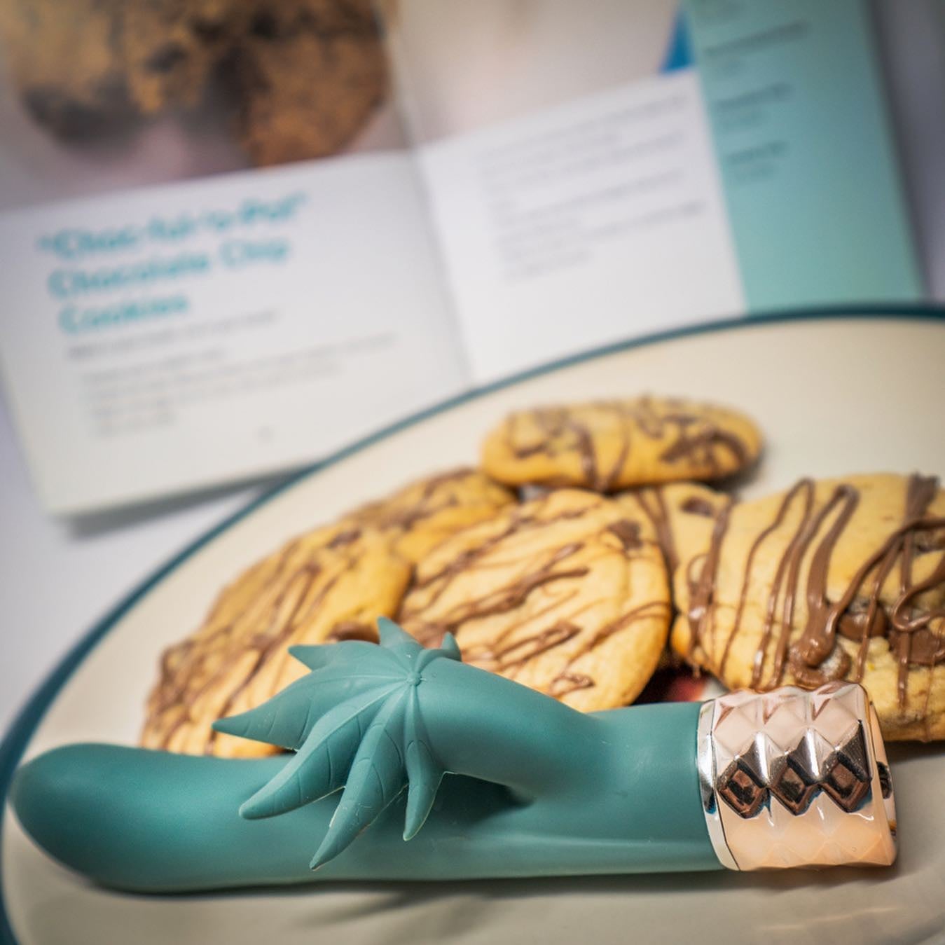 Green vibrator with cannabis leaf accent on plate of cookies
