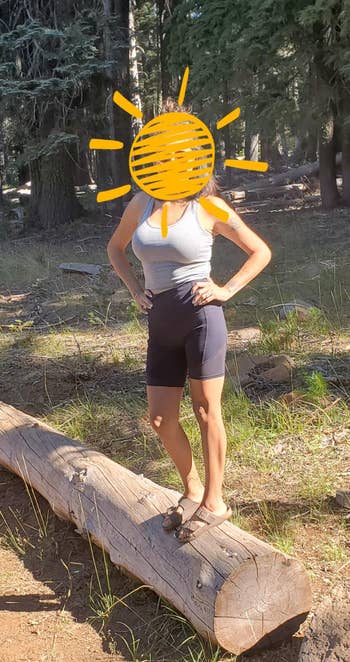 Reviewer standing on log outside wearing black mesh bike shorts