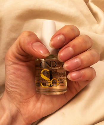another reviewer photo holding the bottle with healthy long nails