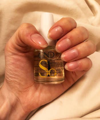 another reviewer photo holding the bottle with healthy long nails