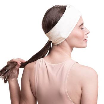 Another model showing the back of the headband with their ponytail slipped through an opening 