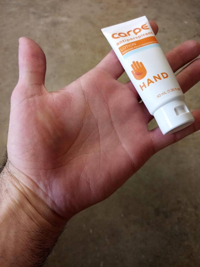 Hand holding a tiny  conduit  of Carpe antiperspirant lotion for hands, highlighting its convenience for managing manus  sweat