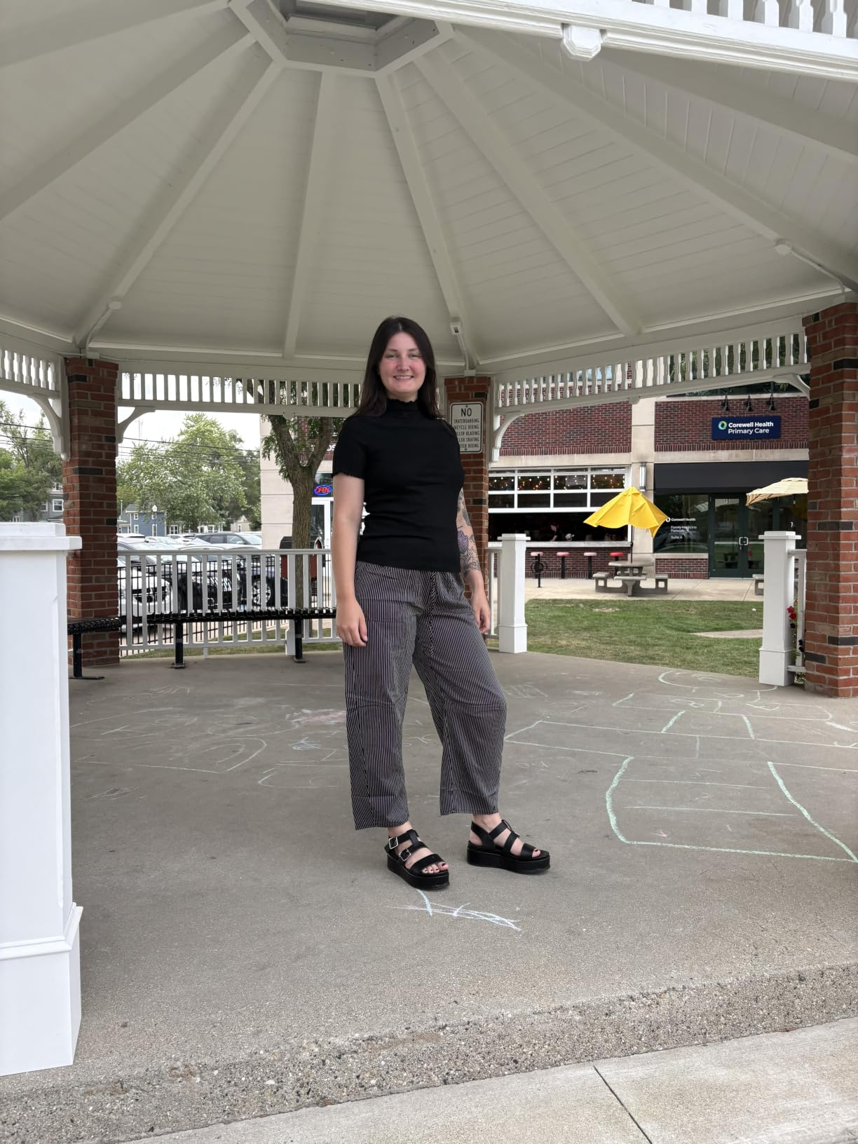 Person successful  a gazebo wearing a achromatic  turtleneck and checkered pants, lasting  connected  a chalk-drawn pavement