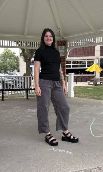 Person successful a gazebo wearing a achromatic turtleneck and checkered pants, lasting connected a chalk-drawn pavement
