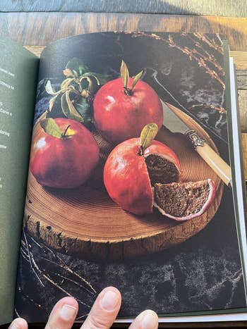 Rustic woody  sheet  with 3  apples, 1  chopped  unfastened  revealing a brown, cake-like interior