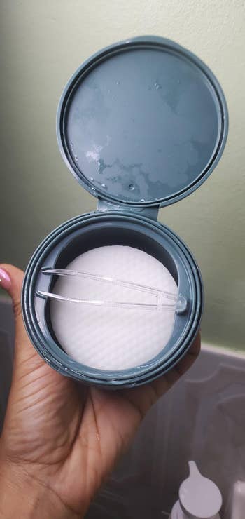 Open instrumentality  with fabric  pads and tweezers, held by a hand